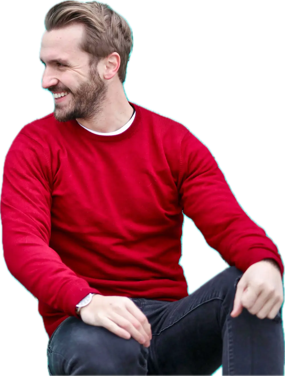 Young man with a beard looking to the side and smiling